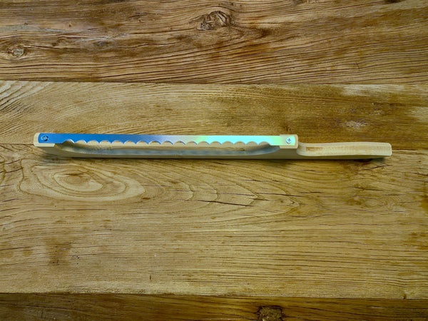 Side view of a bread knife with a bow-shaped handle, designed for precise and ergonomic cutting of bread.