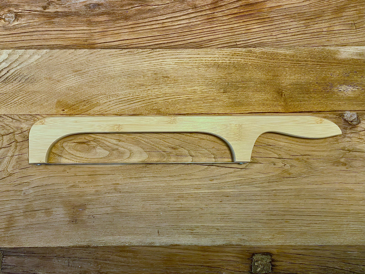 Top-down view of a bread knife with a bow-shaped handle, designed for precise and ergonomic cutting of bread.