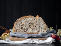 cut open loaf of fresh sourdough on teatowel