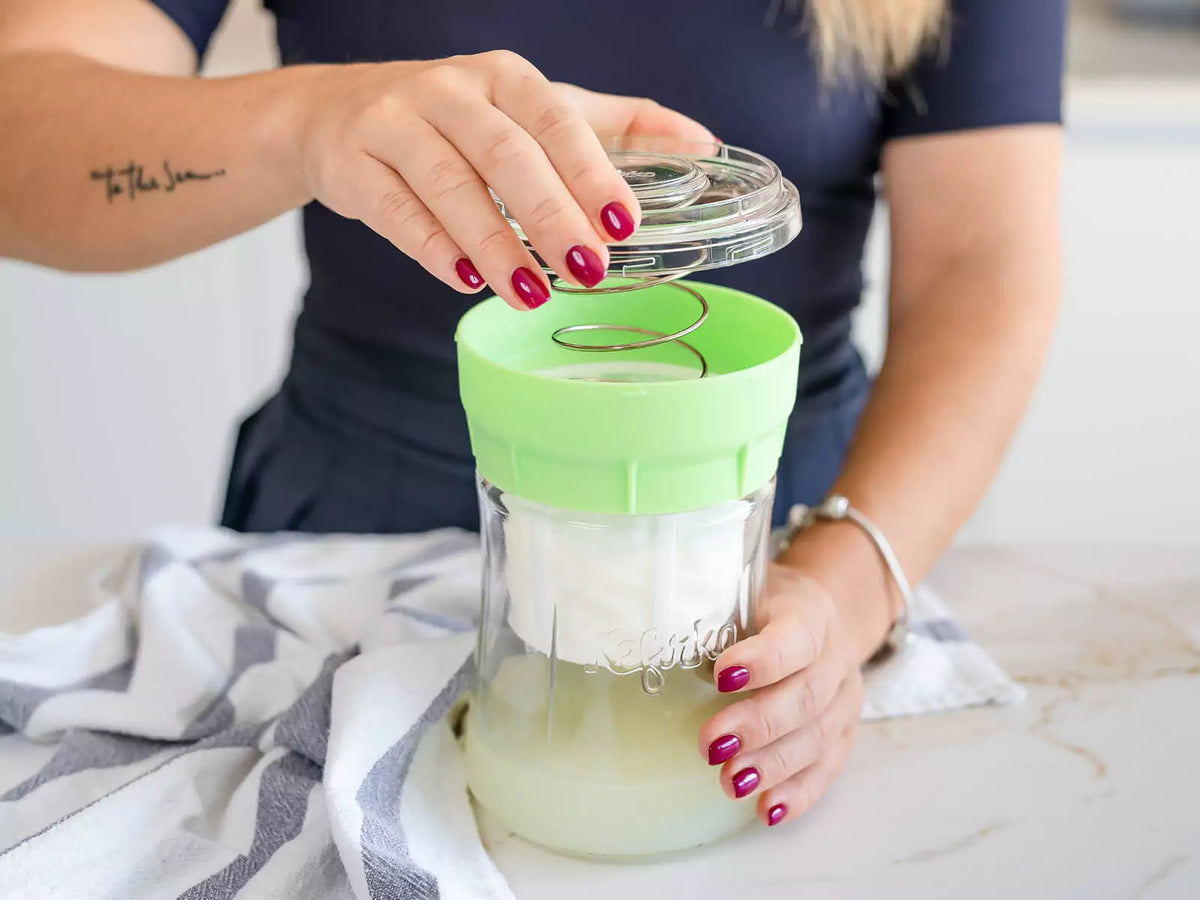 Person using a Kefirko cheese maker.