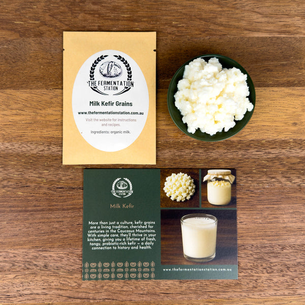 Milk kefir grains and packaging and promotional material on a wooden surface