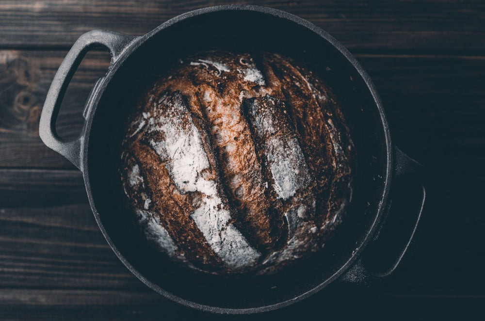 loaf of sourdough bread sitting in dutch oven