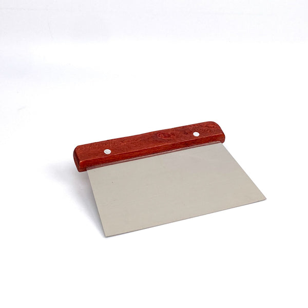 Stainless steel dough scraper with a red wooden handle on a white background.